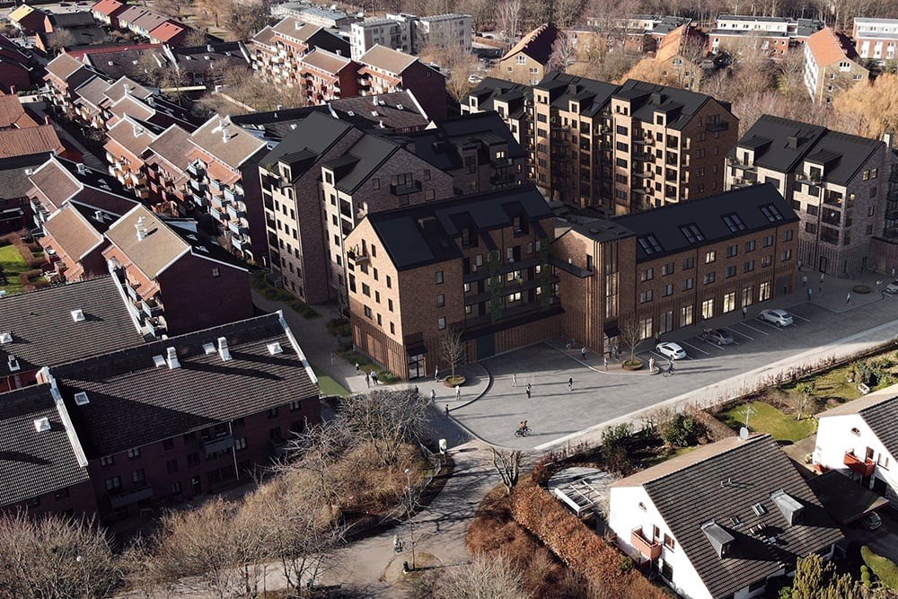 En flygbild av ett urbant område med en variation av byggnader. Det finns flera flervåningshus för 