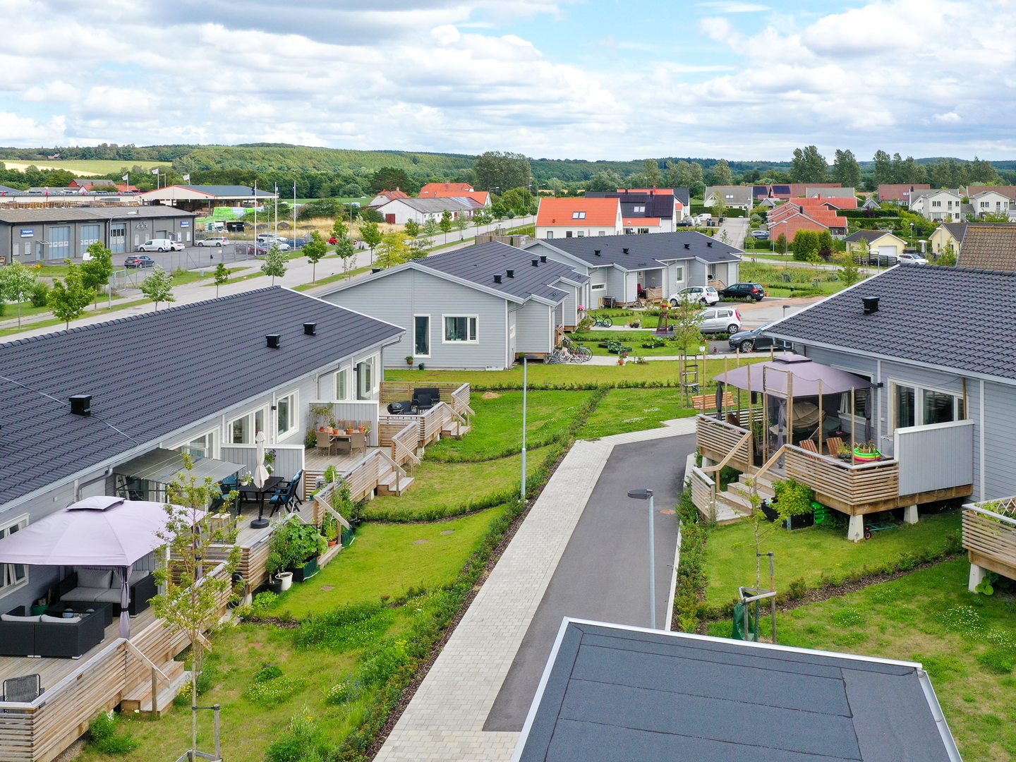 Uteplatserna för de grå radhusen på området, en del har parasoller