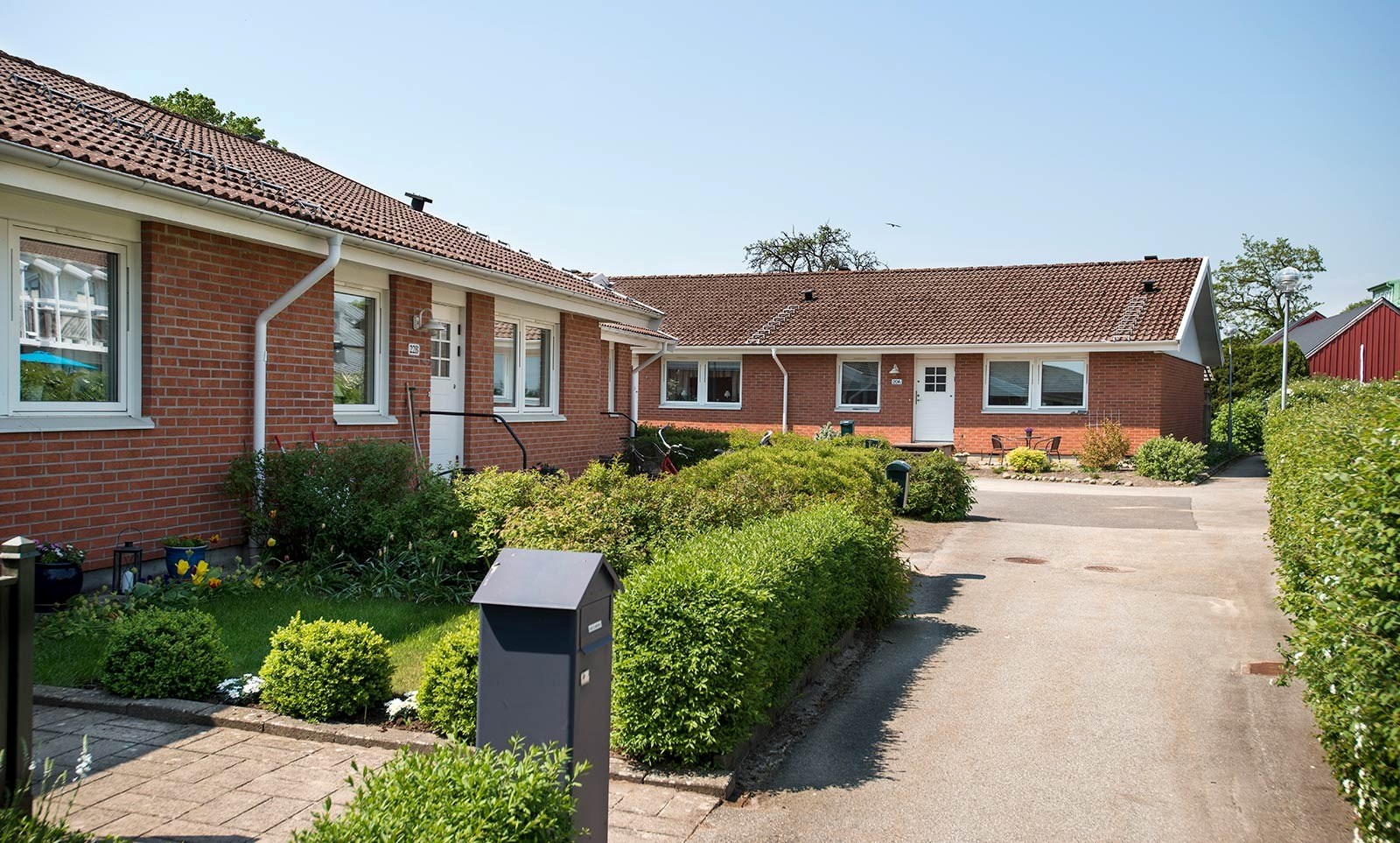 Radhus i solen med buskar utanför