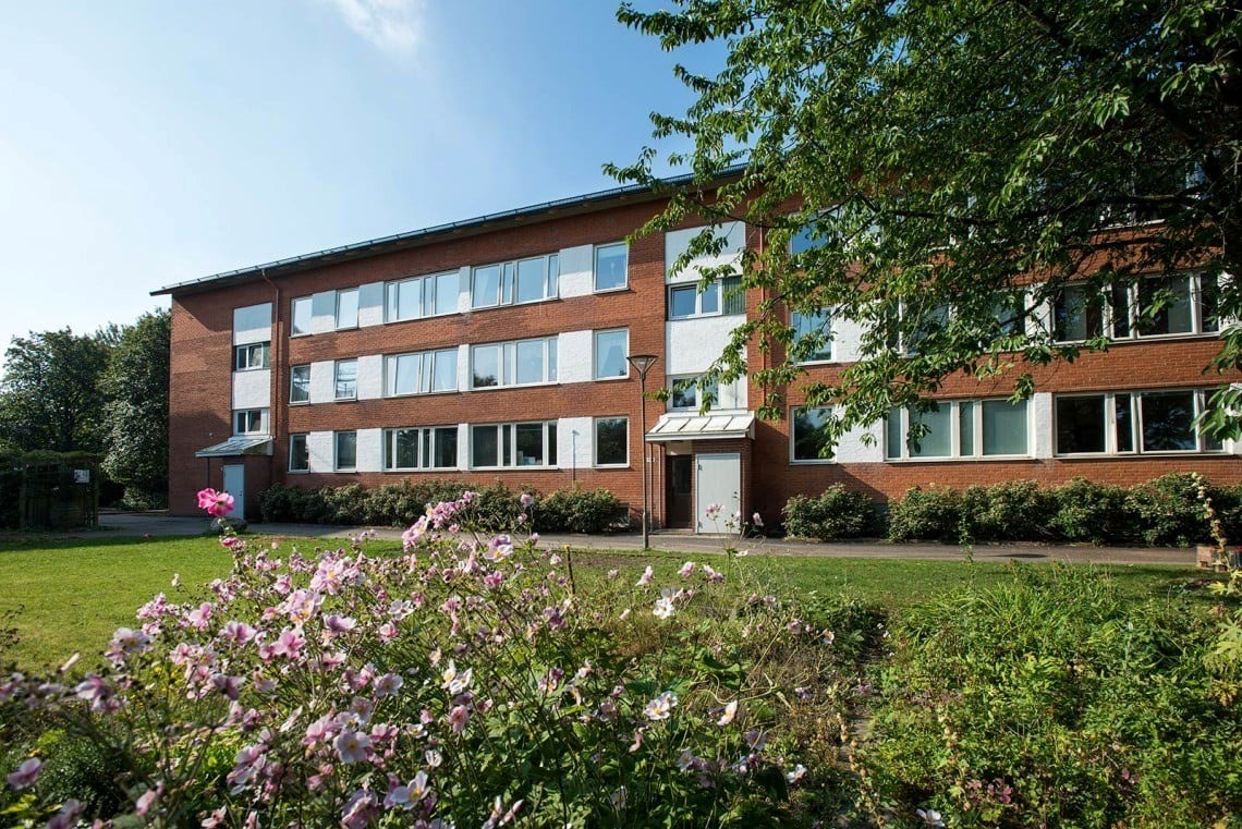 Ett flerfamiljshus i tre plan i ett grönskande område