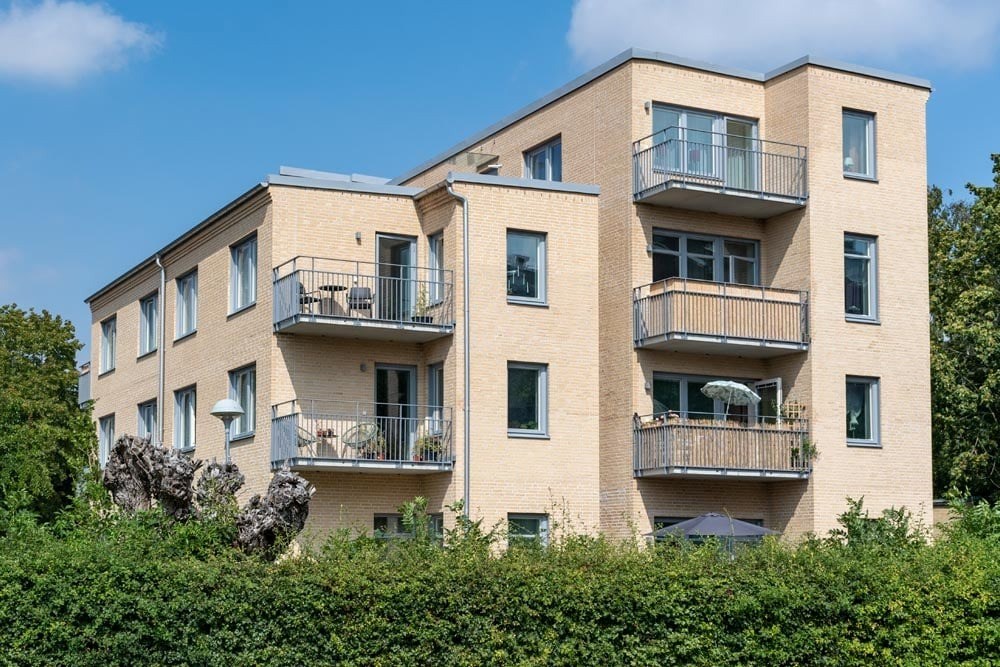 Ett flerfamiljshus med gult tegel och balkonger
